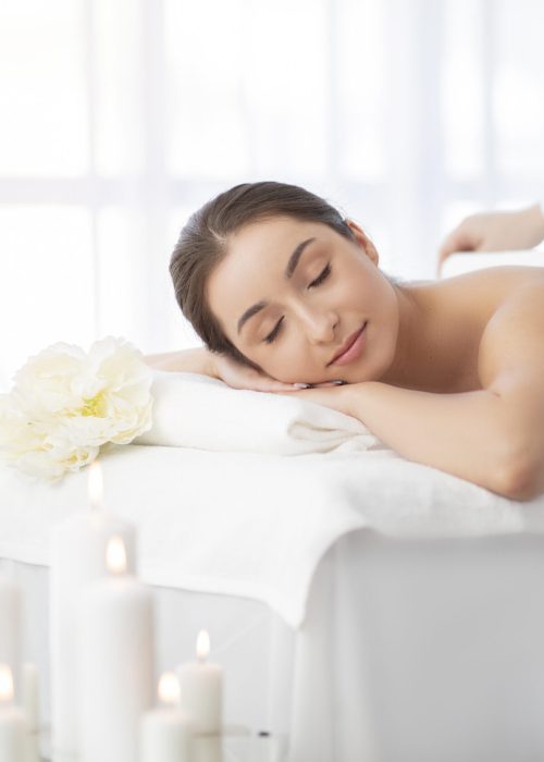 Beautiful Indian Woman Relaxing On Table After Massage Session In Spa Salon Beautiful Young Indian Woman Relaxing On Table After Massage Session In Luxury Spa Salon, Unrecognizable Masseur Covering Female Client With Towel After Beauty Wellness Treatment, Copy Space